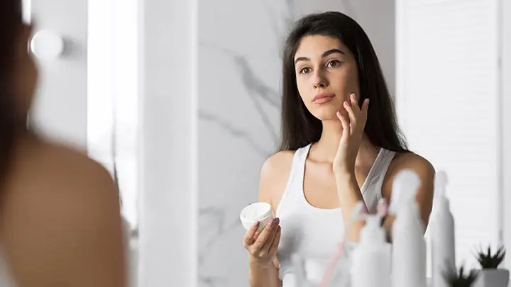 millennial-girl-applying-face-cream-moisturizing-small