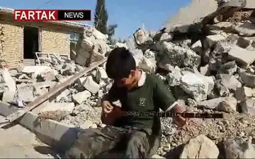 ساز زدن کودک کُرد در خرابه های زلزله روستای قره‌بلاغ سرپل ذهاب + فیلم