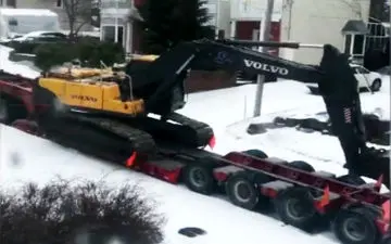 تلاش جالب بیل مکانیکی برای نجات تریلی از جاده برفی + فیلم
