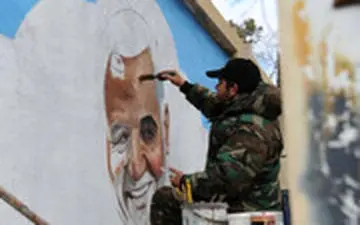  نقاشی چهره شهید حاج قاسم سلیمانی روی دیوار روبروی حرم حضرت زینب(س)