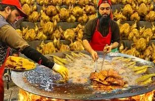 مهارت آشپزی در خیابان‌های پاکستان: تماشای کباب شدن 15 مرغ دور آتش (ویدئو)