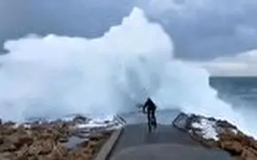 رکاب زدن یک جوان اسپانیایی به سمت امواج دریا