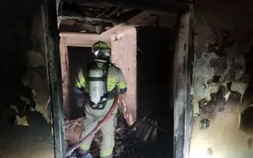 محبوس شدن زن مُسن پشت در بسته در میان دود و آتش