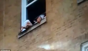 لحظه آویزان ماندن دو بچه از پنجره طبقه دوم یک ساختمان+فیلم