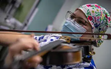 پرستاری که برای بیماران کرونایی ویولن می‌نوازد