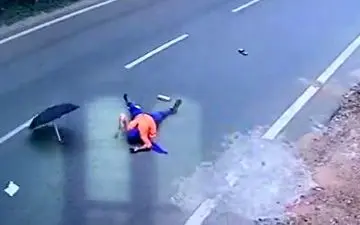 افتادن یک زن از روی موتور به دلیل باز کردن چتر + فیلم