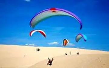 فرود جالب چترباز حرفه‌ای روی شن‌های ساحل دریا 